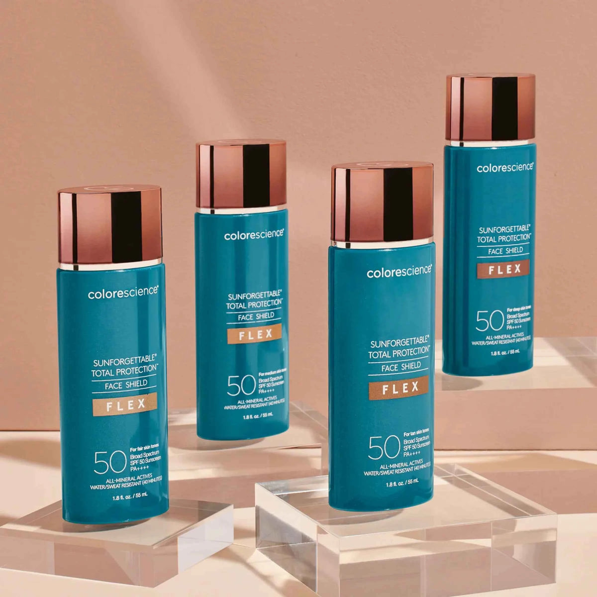 Four Colorescienr Flex sunforebilitary total protection face shields in a teal blue color with metallic rose gold caps, arranged on clear acrylic pedestals against a warm beige background.