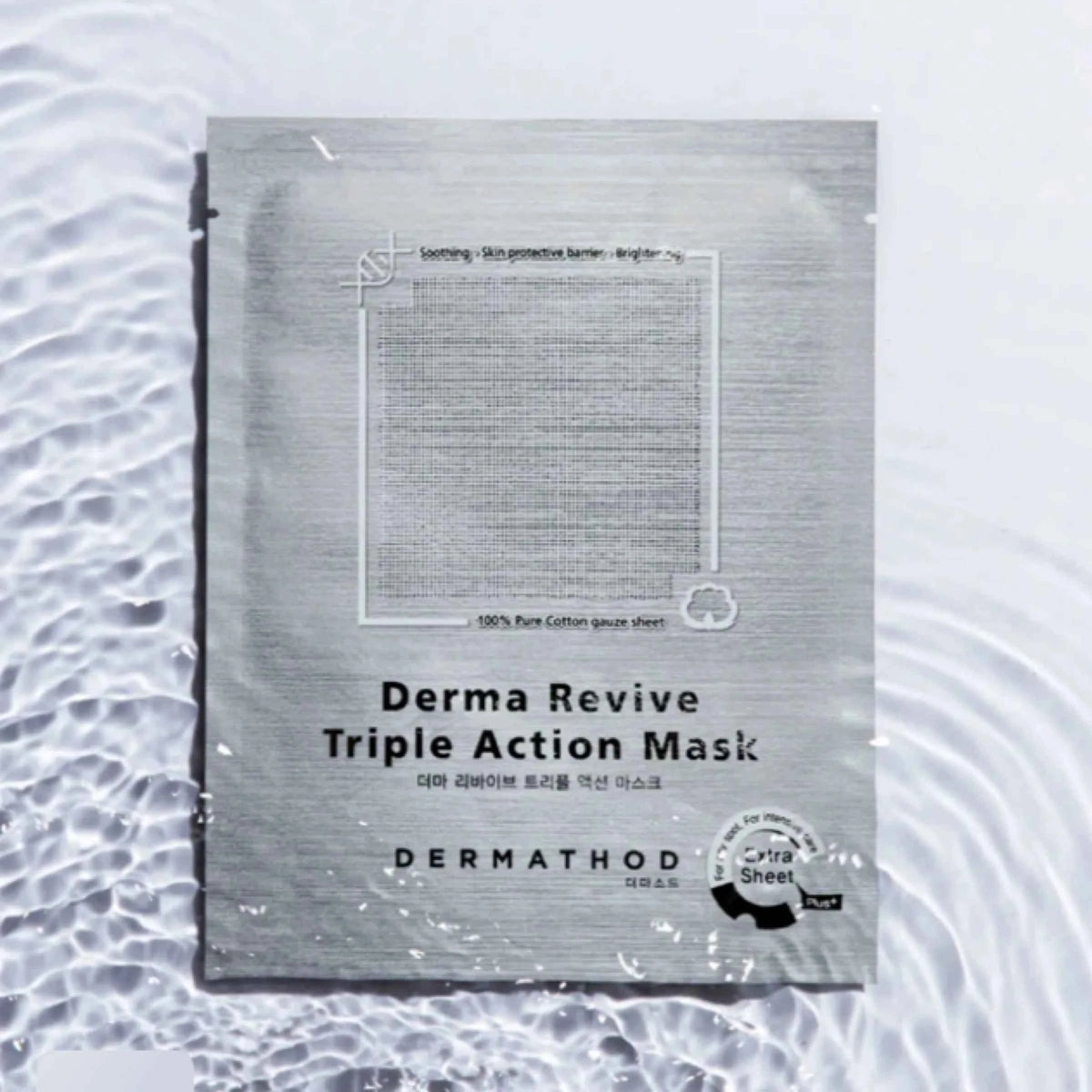 A single DermaThod Derma Revive Triple Action Mask sachet lies on a white surface with water ripples around it. The sachet is metallic silver-gray with black text and a small circular black-and-white certification-style seal near the bottom right.
