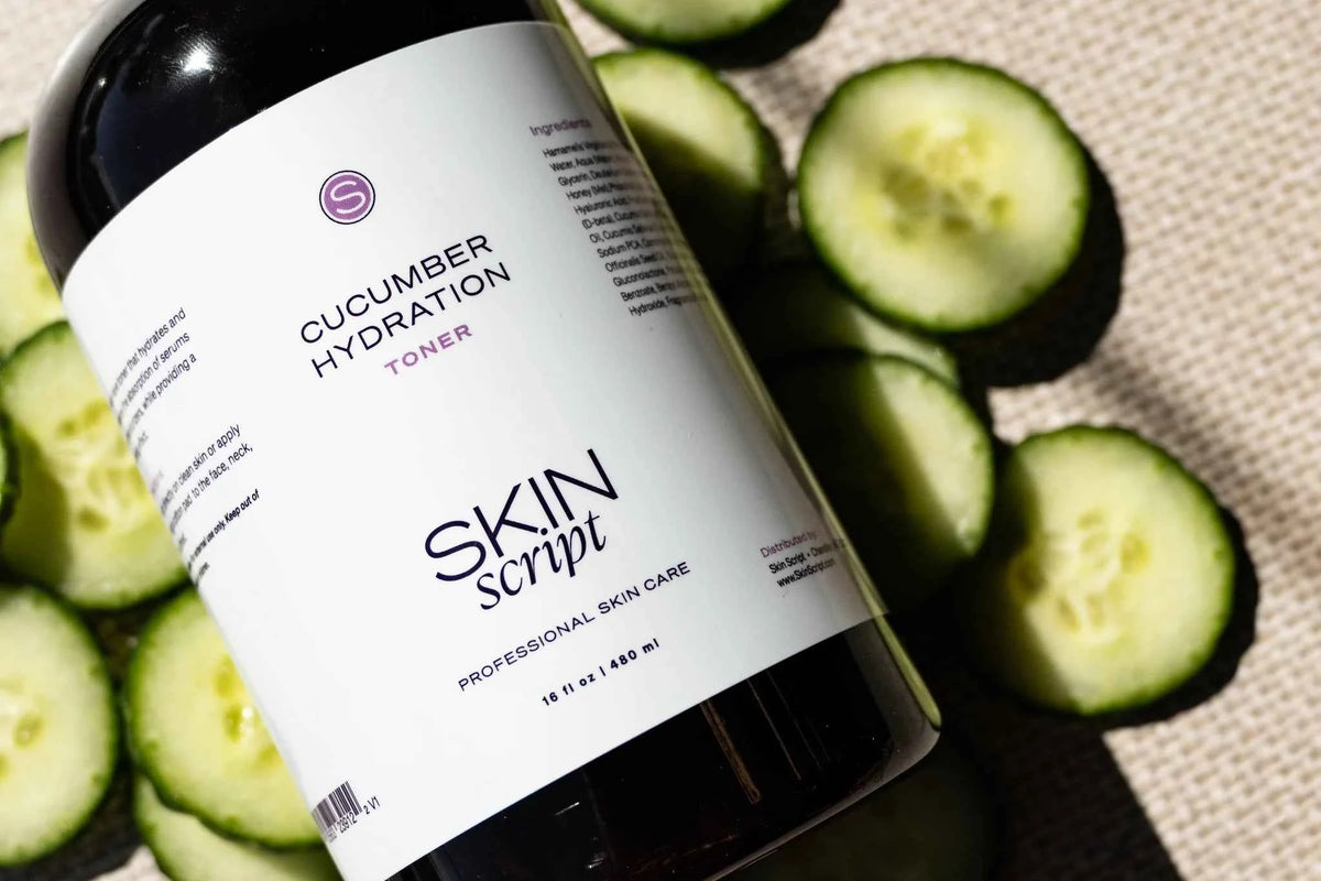 A bottle of Skin Script Cucumber Hydration Toner with a white label, styled with fresh sliced cucumbers on a textured beige fabric background.