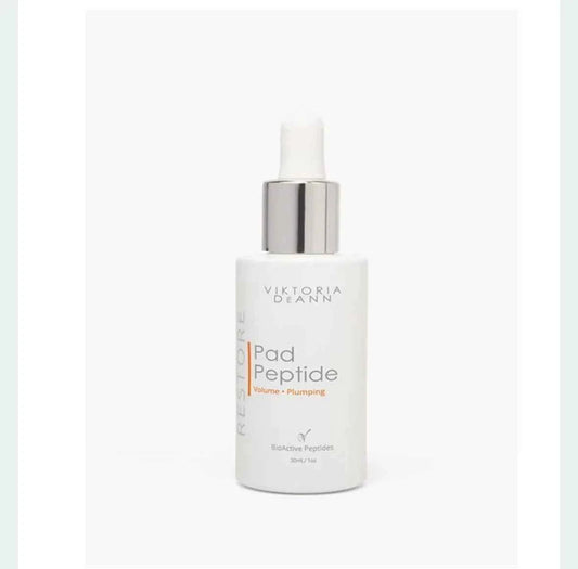 A white bottle of Victoria Deann Restore Pad Peptide with a silver pump dispenser and white dropper cap, set against a plain white background.